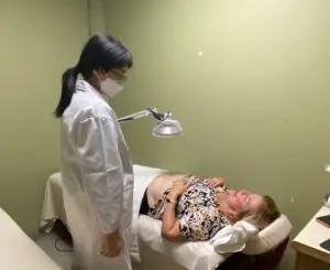 Chinese Acupuncturist, Dr. Shirley Cai, evaluating acupuncture cost on patient alongside initial treatment/consultation.